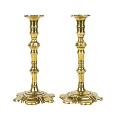 Lot 177 - A pair of George III brass candleholders with petal bases.