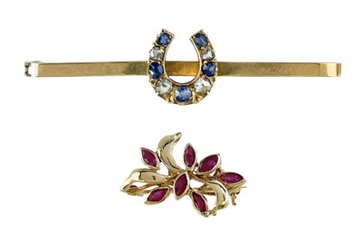 Lot 194 - A 9ct diamond and sapphire set horseshoe bar brooch and a 9ct ruby set floral brooch.