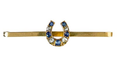 Lot 194 - A 9ct diamond and sapphire set horseshoe bar brooch and a 9ct ruby set floral brooch.