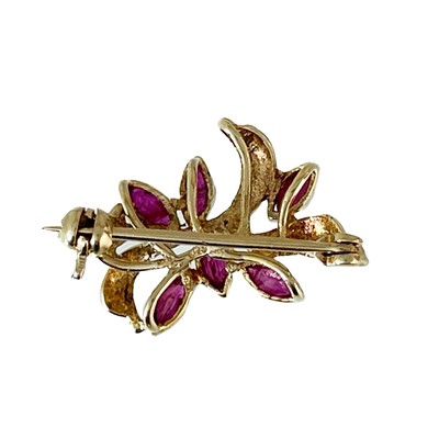 Lot 194 - A 9ct diamond and sapphire set horseshoe bar brooch and a 9ct ruby set floral brooch.