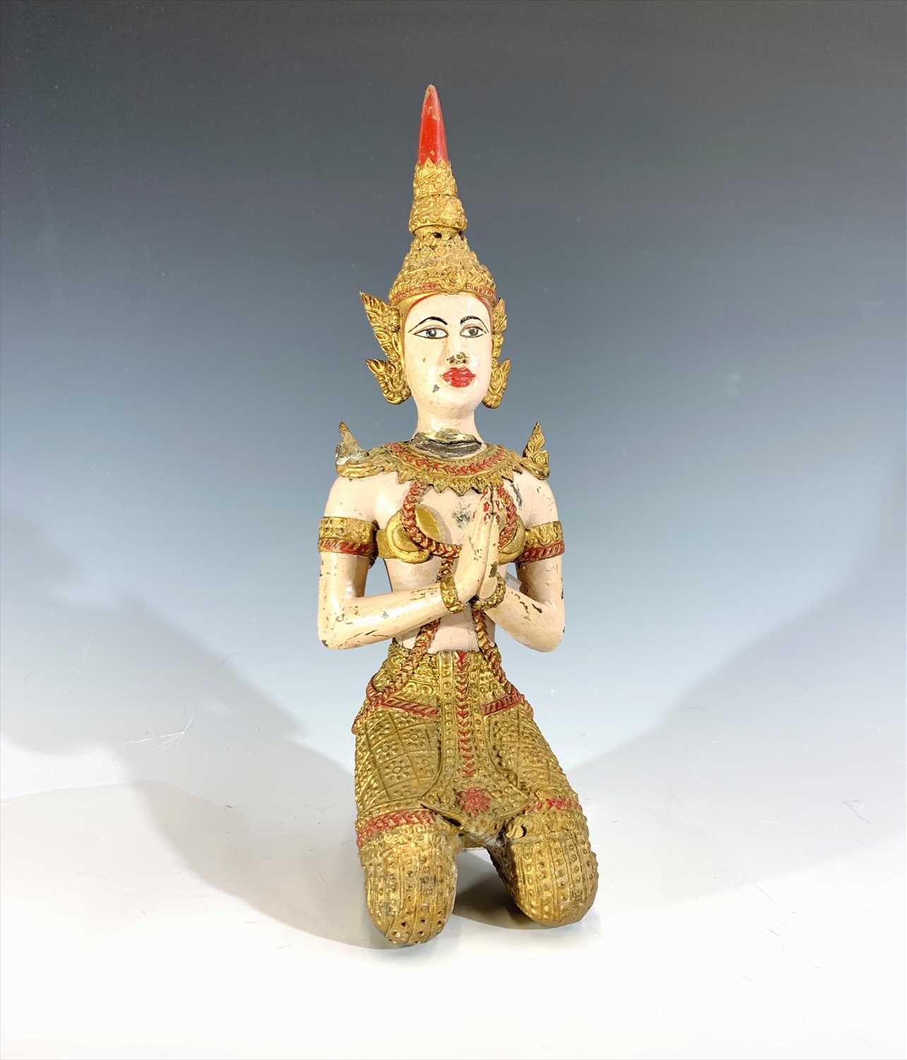 Lot 336 - A painted brass figure of a kneeling Balinese...