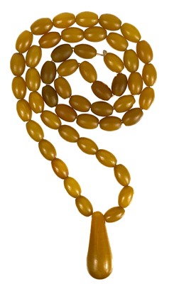 Lot 1086 - A butterscotch 'amber' style oval bead necklace.