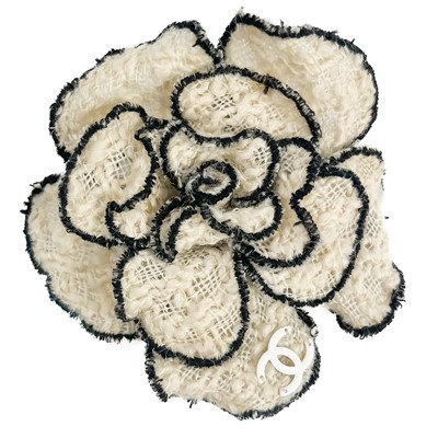 Lot 498 - A Chanel white and black boucle camelia fabric flower brooch.