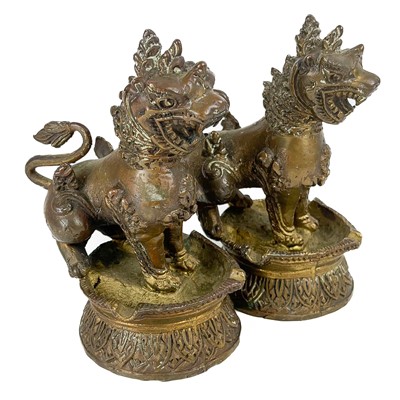 Lot 1440 - A pair of Chinese bronze oil lamps.