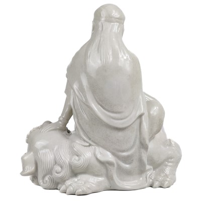Lot 1341 - A Chinese blanc de chine figure of Guanyin upon a dog of fo.