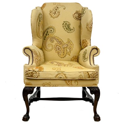 Lot 749 - A good George II style walnut carved upholstered wing back armchair.