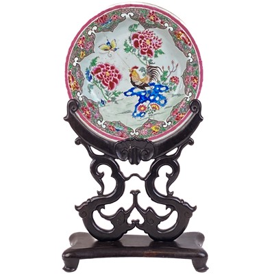 Lot 1451 - A Chinese famille rose dish, 18th century, on a carved wood stand, circa 1900..