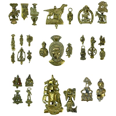 Lot 191 - A collection of twenty-eight brass souvenir novelty door knockers.