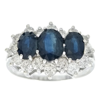 Lot 83 - An 18ct white gold blue sapphire and diamond triple cluster ring.