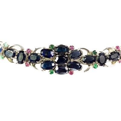 Lot 7 - A contemporary 925 silver sapphire bracelet with emerald and ruby accents.