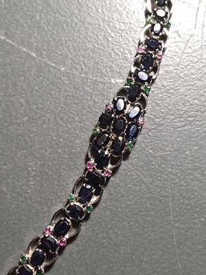 Lot 82 - A contemporary 925 silver sapphire bracelet with emerald and ruby accents.