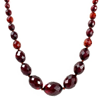 Lot 384 - A cherry amber bakelite faceted bead necklace.