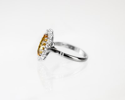 Lot 55 - An 18ct white gold Imperial Topaz and diamond set cluster ring.