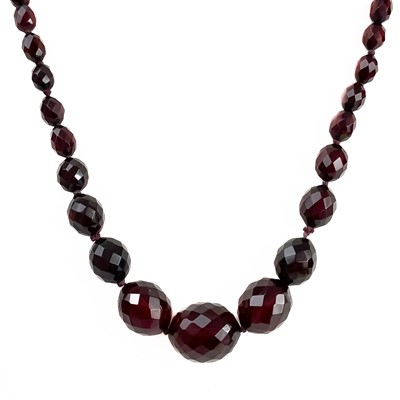 Lot 394 - A cherry amber bakelite faceted bead necklace.