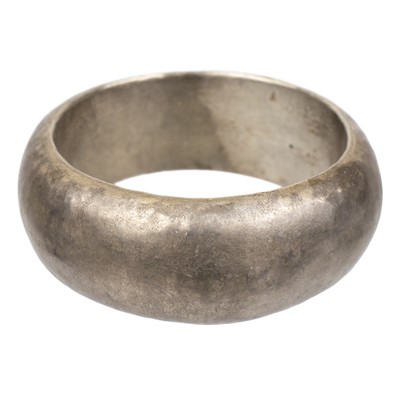 Lot 337 - A hammered silver bangle by Guy Royle.