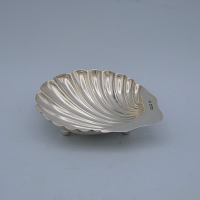 Lot 35 - An Edwardian silver pair of scallop shell butter dishes by James Deakin & Sons, and one other.