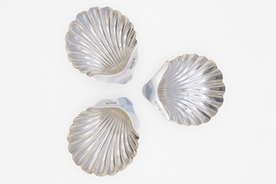 Lot 35 - An Edwardian silver pair of scallop shell butter dishes by James Deakin & Sons, and one other.