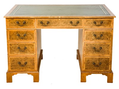 Lot 105 - A 20th century figured yew pedestal desk by Abbey Reproductions, Penzance.