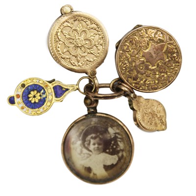 Lot 8 - A selection of four gold charms and a rolled gold frame glazed panel locket.