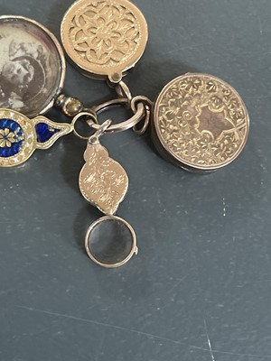 Lot 8 - A selection of four gold charms and a rolled gold frame glazed panel locket.