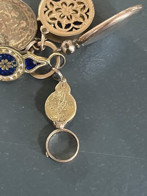 Lot 8 - A selection of four gold charms and a rolled gold frame glazed panel locket.