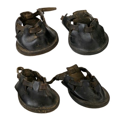 Lot 195 - A set of four leather pony shoes.