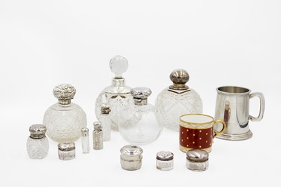 Lot 98 - A collection of cut glass silver lidded scent bottles.