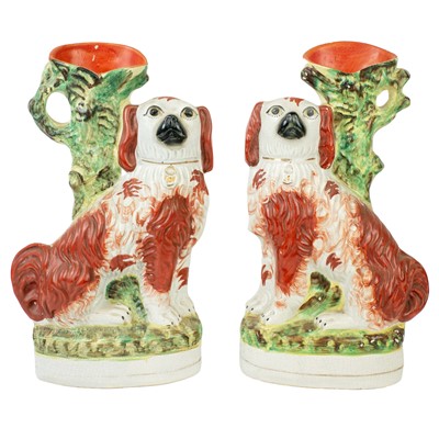Lot 10 - A pair of Victorian Staffordshire pottery spaniel spill vases.