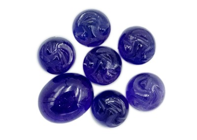 Lot 351 - Seven cabochon amethyst stones, six are carved with man on the moon faces.