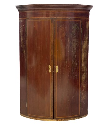 Lot 73 - A George III mahogany bow front hanging corner cupboard.