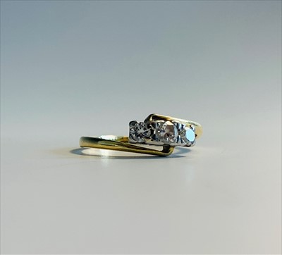 Lot 2576 - An 18ct gold three diamond crossover ring.