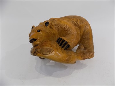 Lot 40 - A carved wood sculpture of a bear with a fish...
