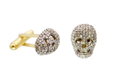 Lot 175 - A contemporary silver-gilt pair of diamond set skull cufflinks.