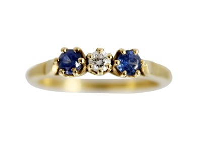 Lot 219 - An 18ct diamond and sapphire set three-stone ring.