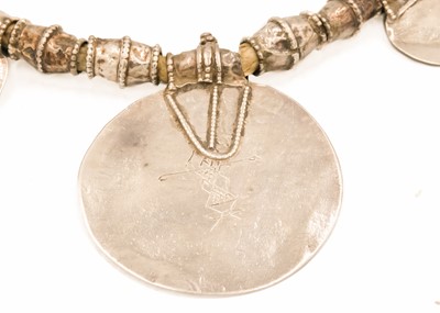Lot 62 - An Omani silver amulet with four coins.