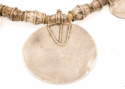 Lot 104 - An Omani silver amulet with four coins.