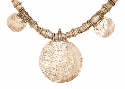 Lot 62 - An Omani silver amulet with four coins.