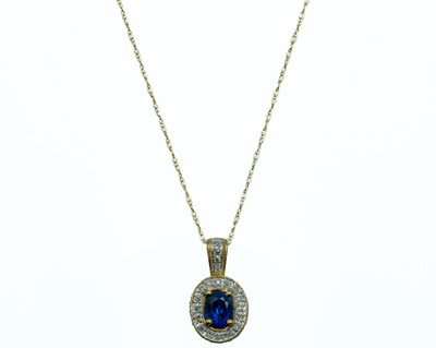 Lot 273 - A 9ct diamond and blue sapphire set pendant.