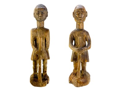 Lot 271 - A pair of African carved wood figures of soldiers holding rifles, on circular bases.