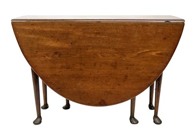 Lot 567 - A George III mahogany drop leaf oval dining table.