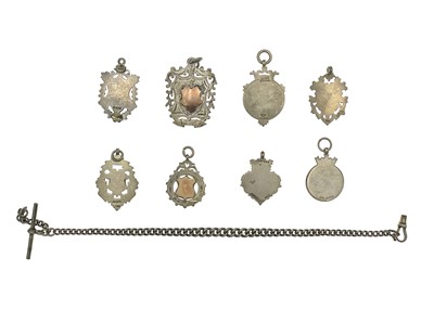 Lot 79 - A selection of eight silver shield watch fobs and a silver Albert watch chain.