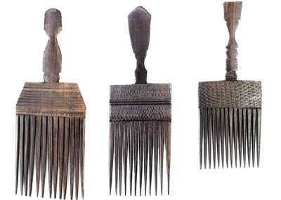 Lot 223 - Three African carved hardwood combs, each with a carved mask handle.