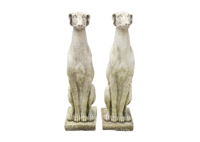 Lot 545 - A pair of small reconstituted stone seated whippet garden ornaments.