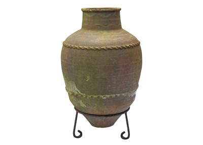 Lot 557 - A terracotta olive jar, with two bands of applied decoration, raised on metal stand.