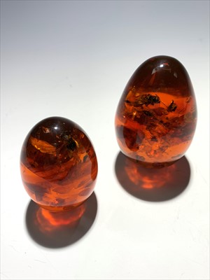 Lot 2523 - Two 'amber' style eggs 173gm