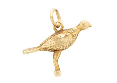 Lot 36 - A high purity gold (tests 18ct) bird on a perch charm pendant.