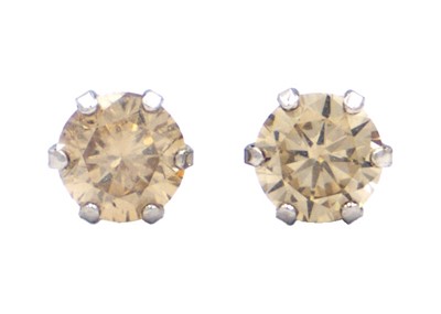 Lot 57 - A pair of 18ct white gold diamond set solitaire stud earrings.