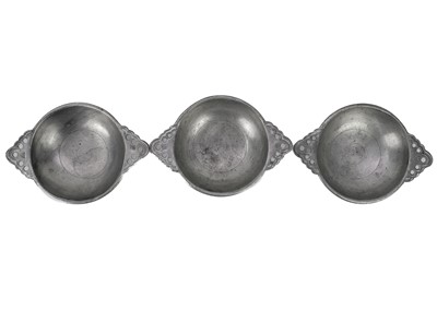 Lot 75 - A set of seven 20th century twin handle pewter porringer bowls with pierced handles.