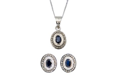 Lot 116 - A diamond and blue sapphire, silver set, earring and pendant necklace suite.