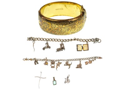 Lot 297 - A silver gilt engraved bangle and two silver charm bracelets.